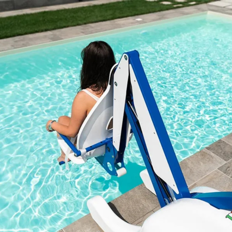 Pool lift with a padded seat fixed at the edge of an outdoor swimming pool