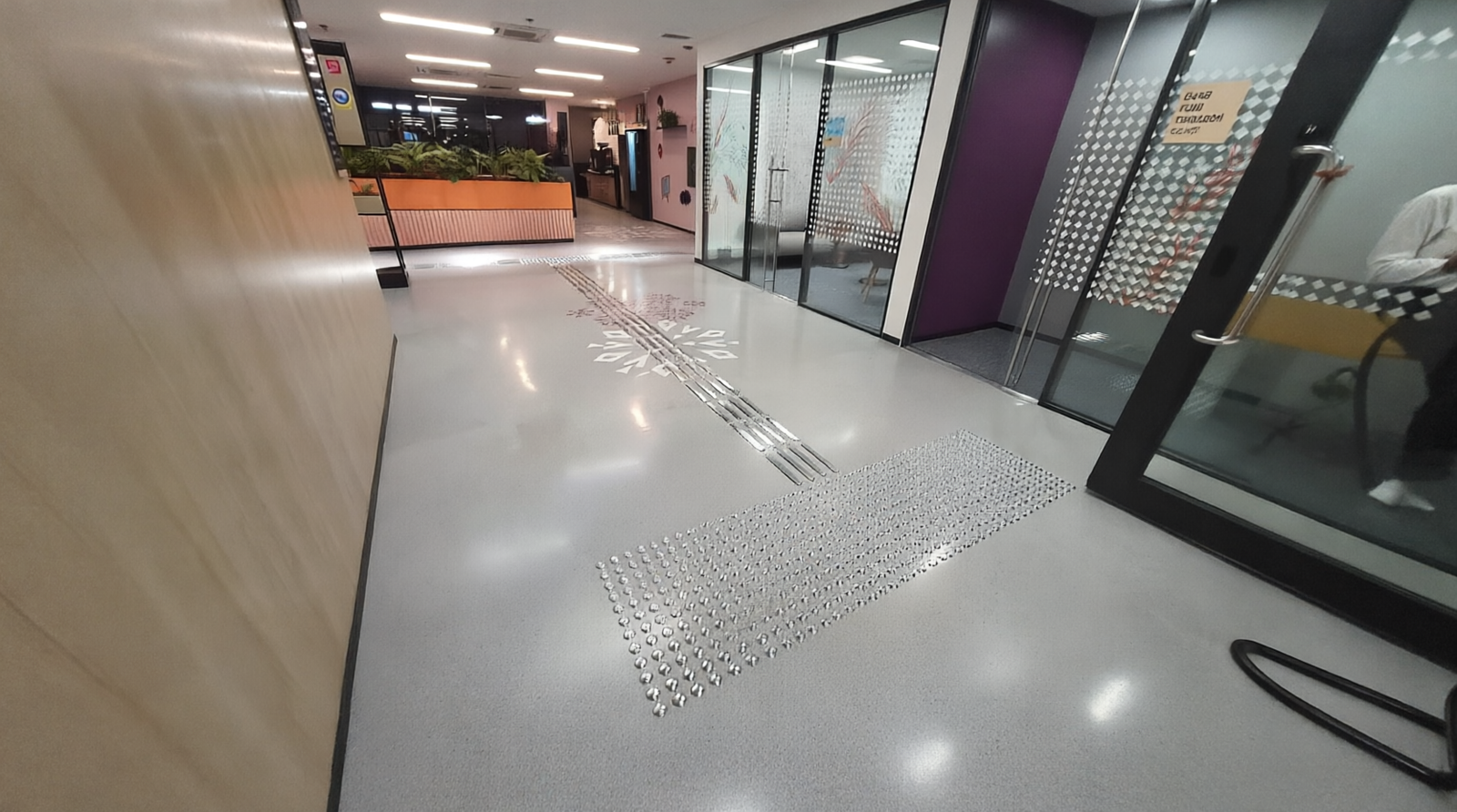 Wheelchair user on an indoor accessible floor at a healthcare facility with tactile guidance system installation UAE