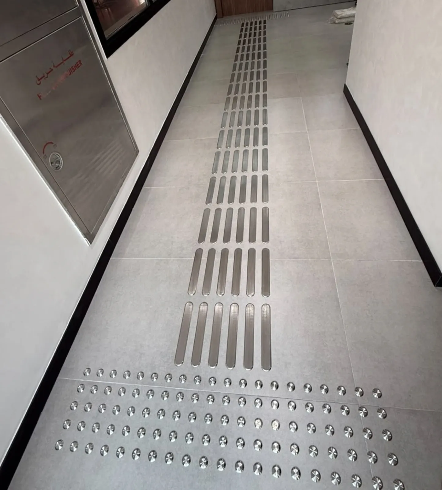 High-contrast yellow tactile tiles at a walkway crossing in Dubai